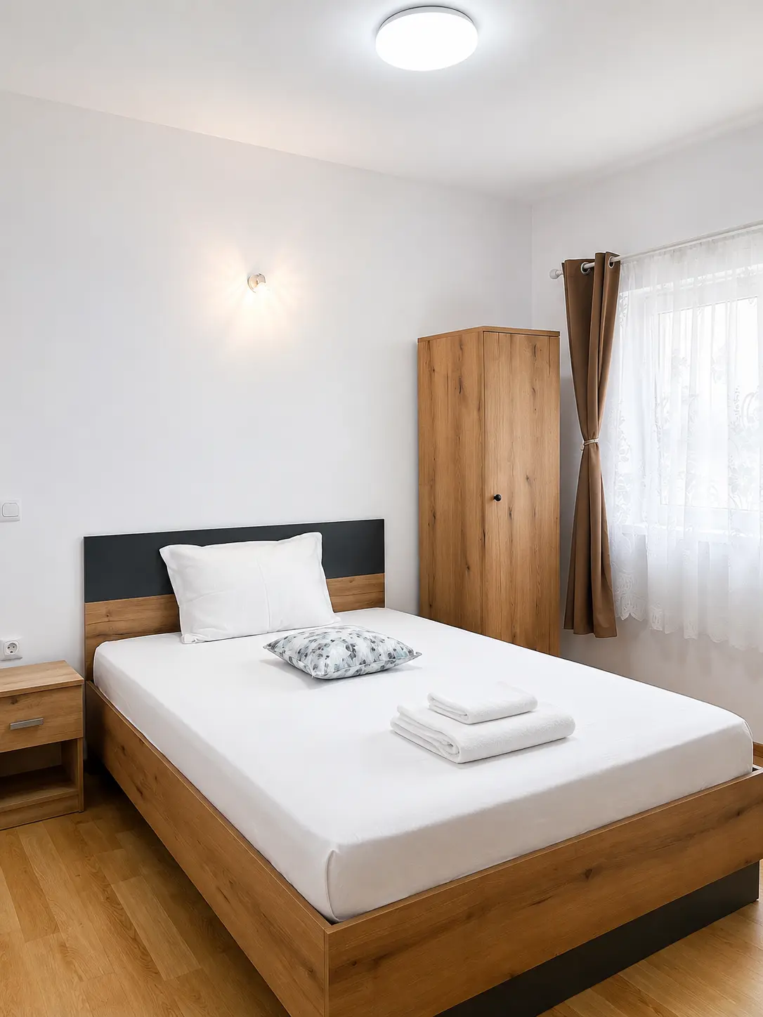 Cameră matrimonială luminoasă la Vila Kamilla, cu mobilier din lemn și textile verzi